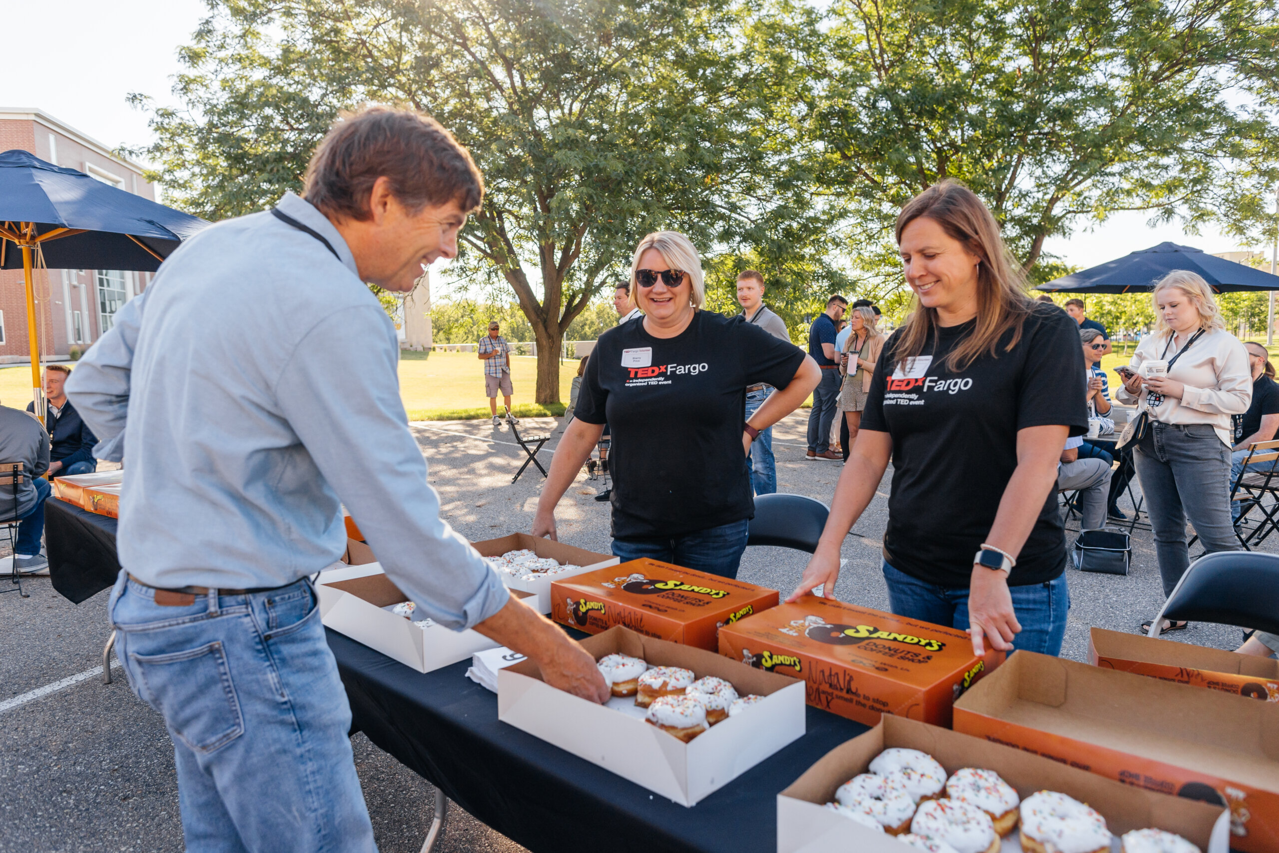 staff helping guest get donuts